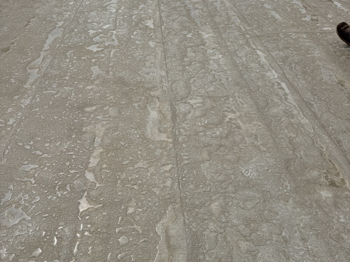 Roof edge near a skylight showing rust staining and membrane wear.